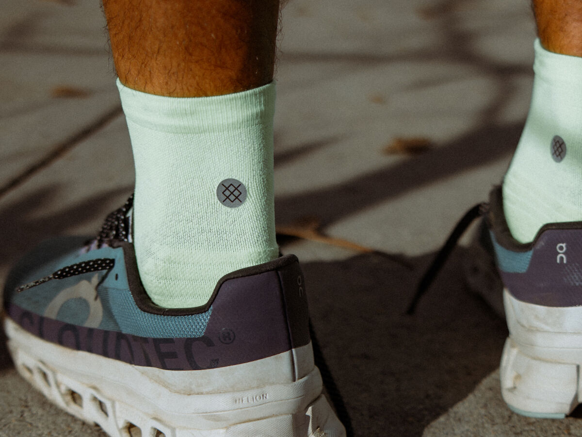 Close up image of person wearing running shoes and blue quarter socks